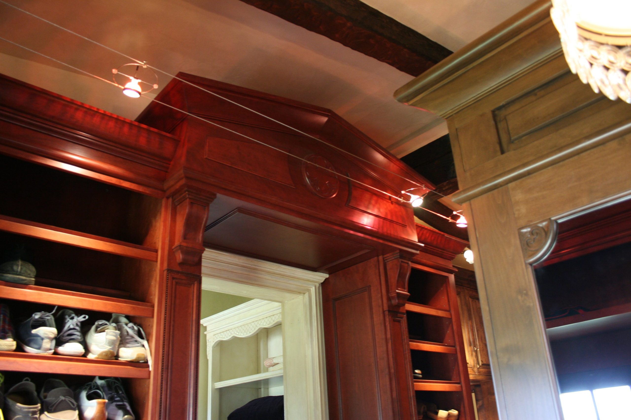Custom architectural millwork featuring rich wood cabinetry, decorative crown moulding, detailed trim, and built-in shelving.
